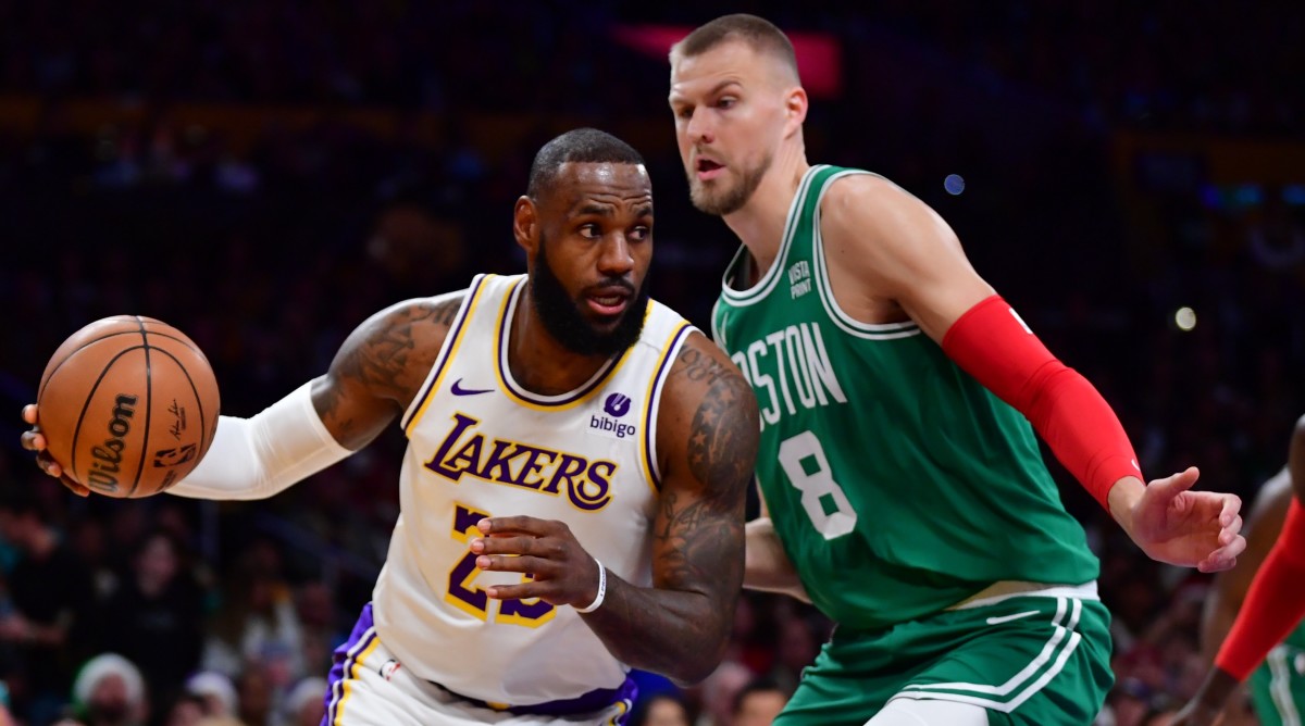 Lakers forward LeBron James, left, moves the ball against Celtics center Kristaps Porzingis